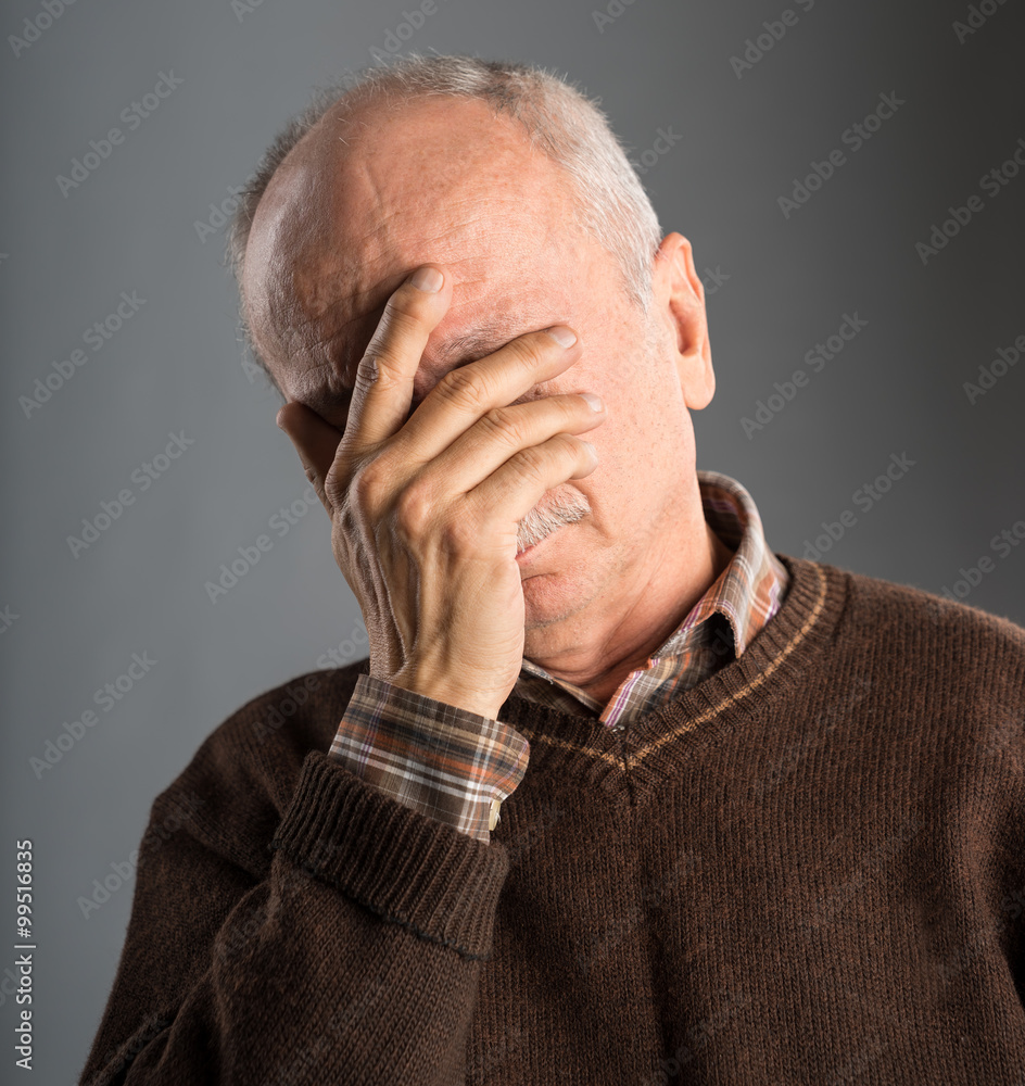 Elderly man suffering from a headache Elderly man suffering from a headache