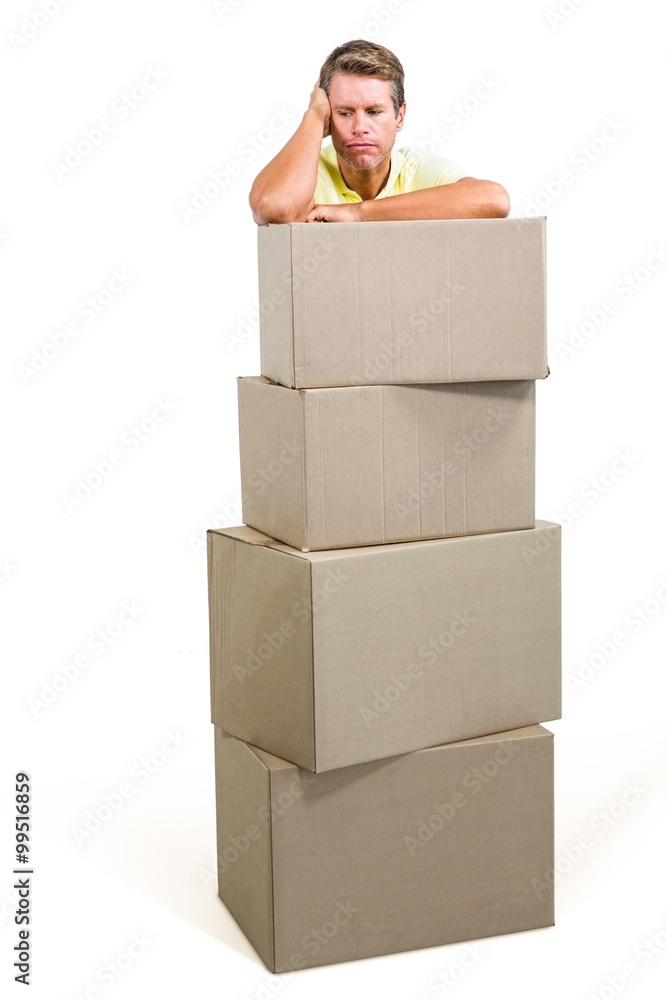Man thinking while standing with boxes Man thinking while standing with boxes