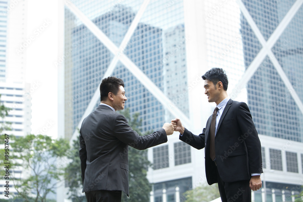 Excited businessmen celebrating and doing fist bump, Hong Kong Excited businessmen celebrating and doing fist bump, Hong Kong
