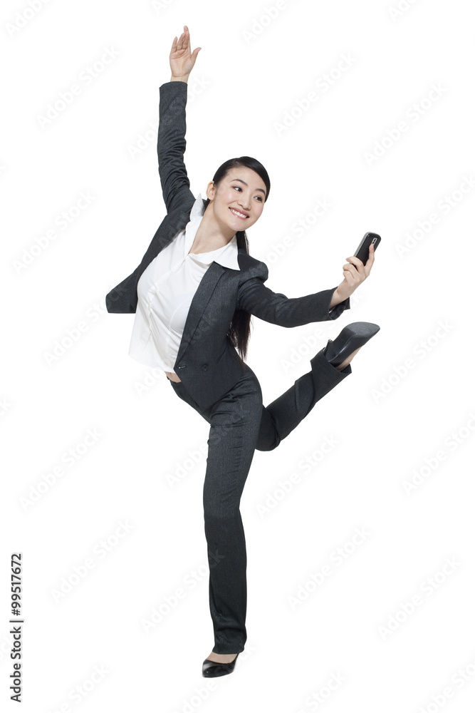 A dancing businesswoman holding a mobile phone A dancing businesswoman holding a mobile phone