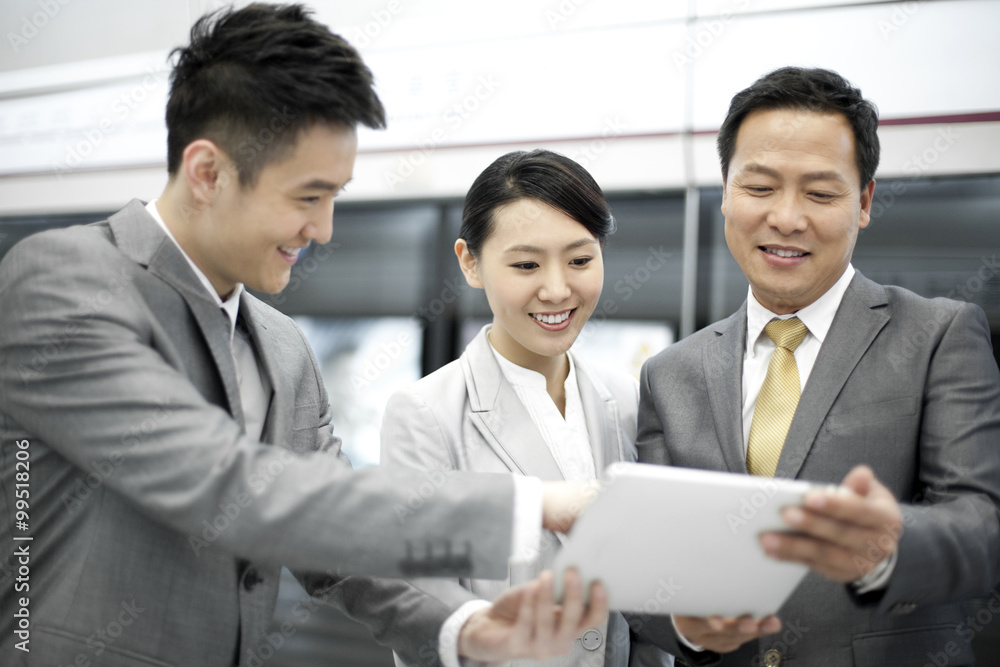 Cheerful business persons with digital tablet on subway platform Cheerful business persons with digital tablet on subway platform