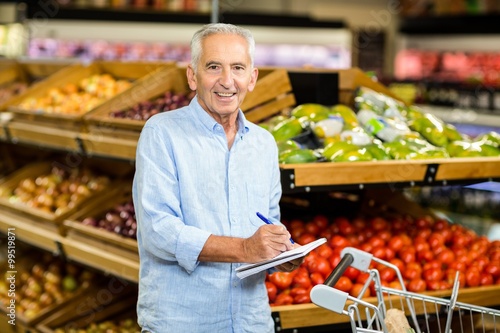 Smiling senior man with shopping list 