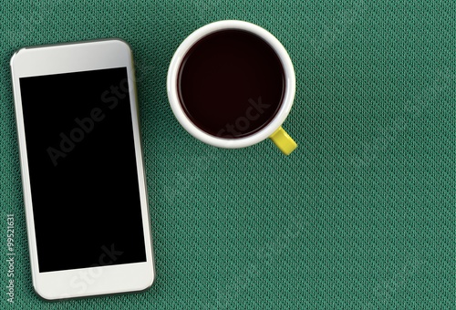 Coffee cup with smart phone on green fabric table photo