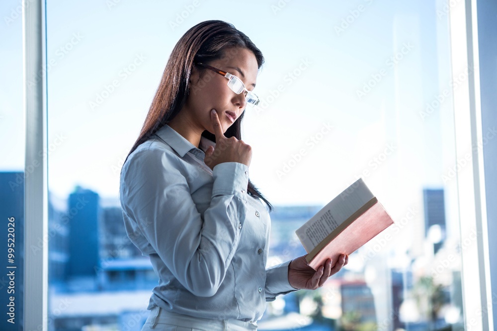 Fototapeta premium Concentrated businesswoman reading book
