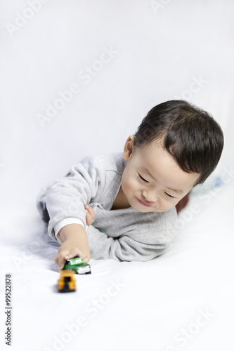 Happy little boy playing toy car