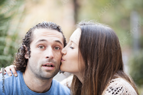 Tableau sur toile Pretty woman kissing man on the cheek