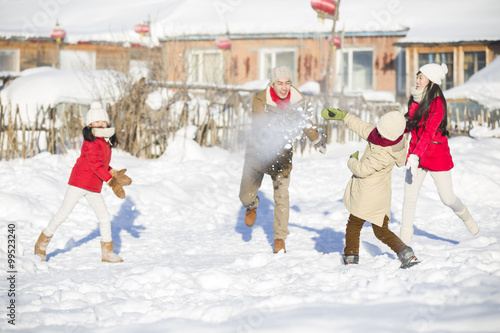 Young family having a snowball fight in the snow