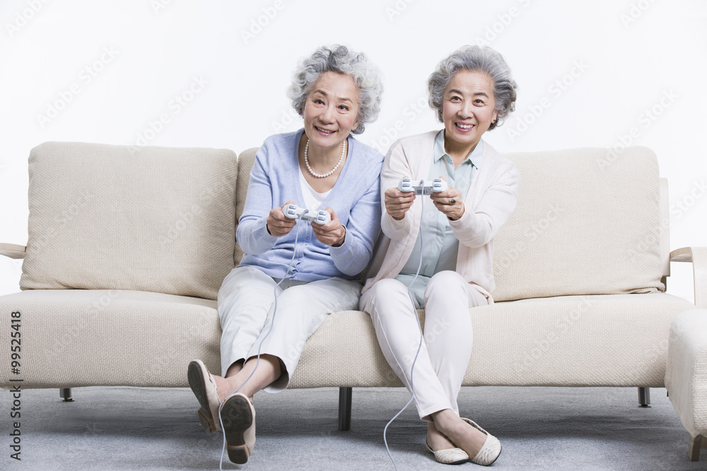 Senior women playing video game in living room