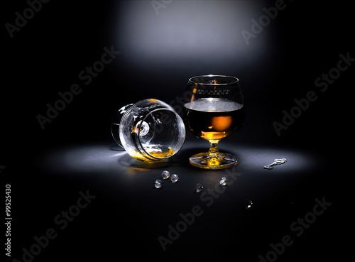 Two glasses of cognac
Two glasses of cognac, one of which overturned. Scattered necklace and a vintage key.
