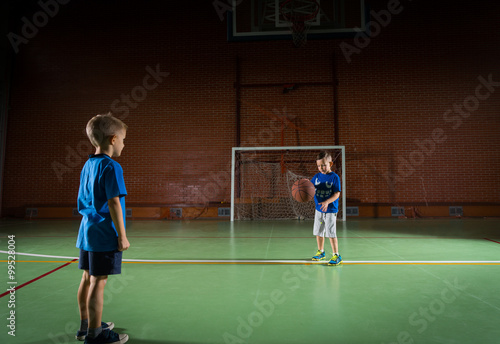 Two young boys playing with a basketball