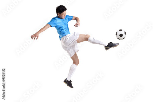Soccer player kicking while jumping © Blue Jean Images