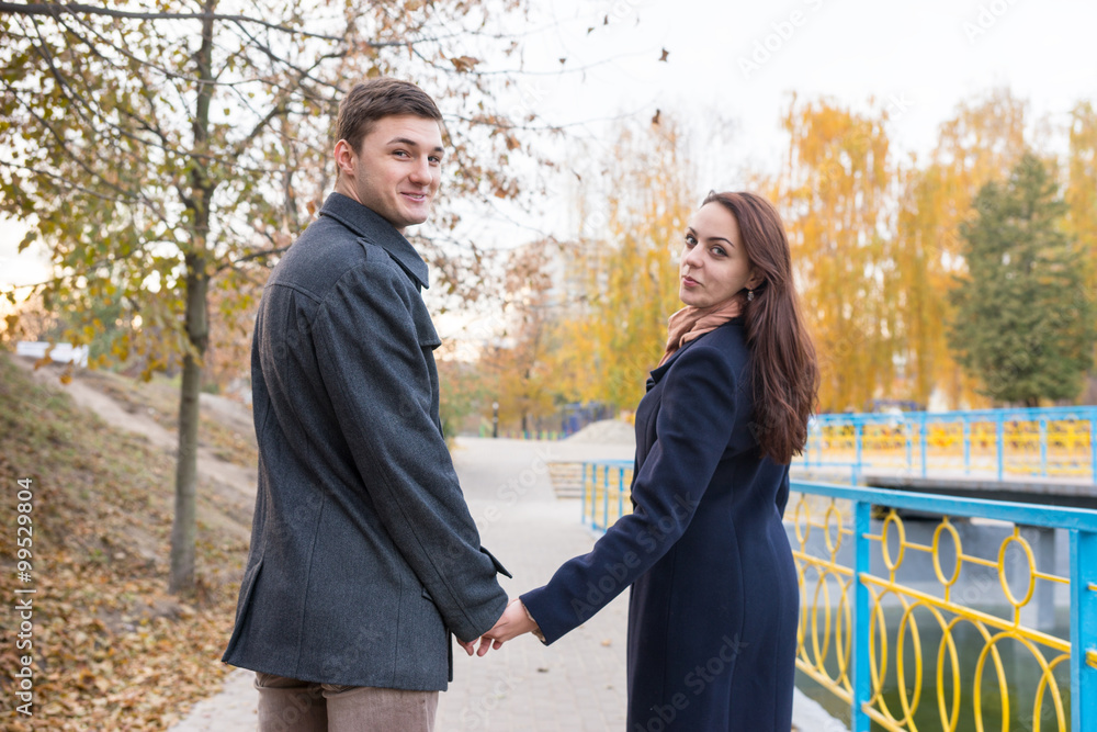 Couple Holding Hands and Looking Back at Camera Couple Holding Hands and Looking Back at Camera
