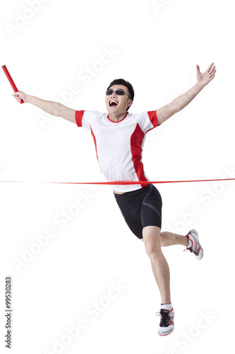 Male athlete with relay baton reaching the finish line