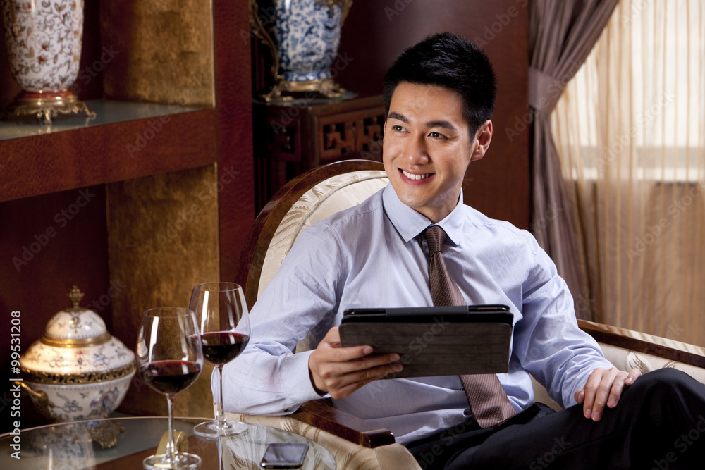 Fototapeta premium Young businessman using digital tablet in hotel