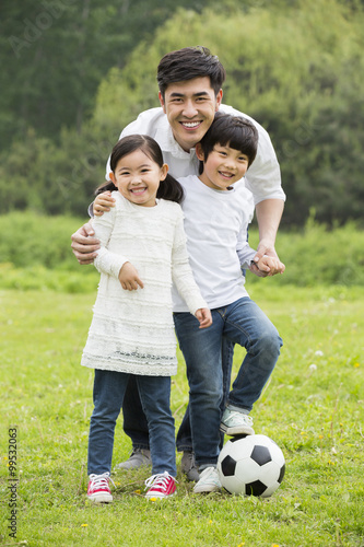 Portrait of father and children with football
