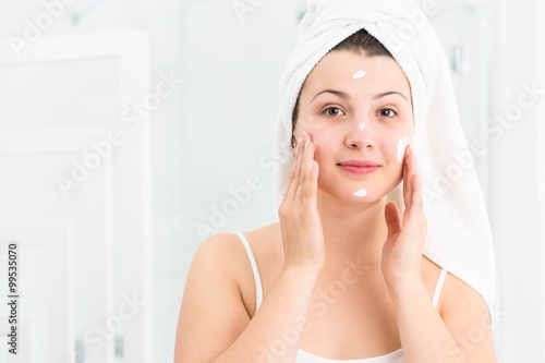Woman using moisturizing cream