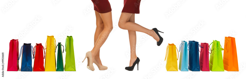 close up of women on high heels with shopping bags