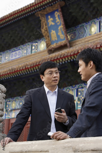 Two Businessmen Talking In The Forbidden City In Beijing photo