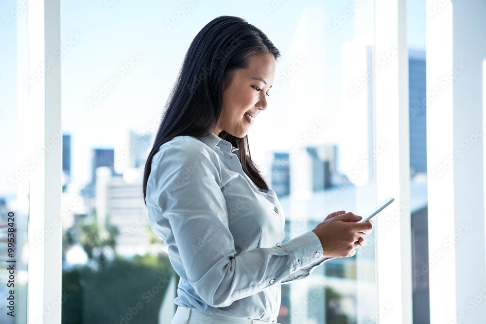 Fototapeta premium Smiling businesswoman using smartphone