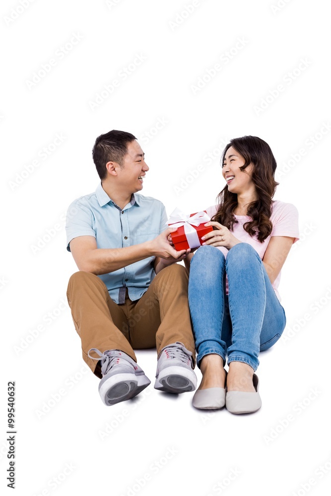 Happy couple with gift looking at each other Happy couple with gift looking at each other