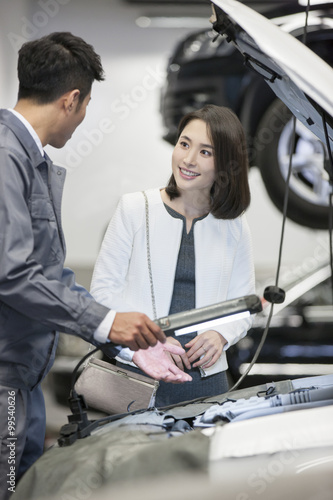 Auto mechanic talking with car owner