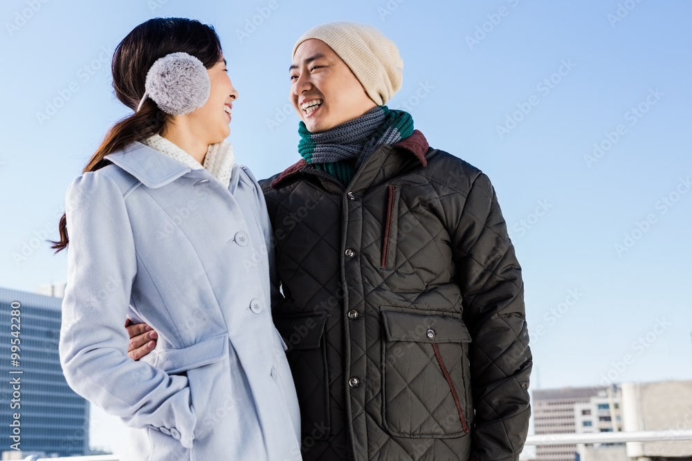Happy couple in warm clothing looking at each other