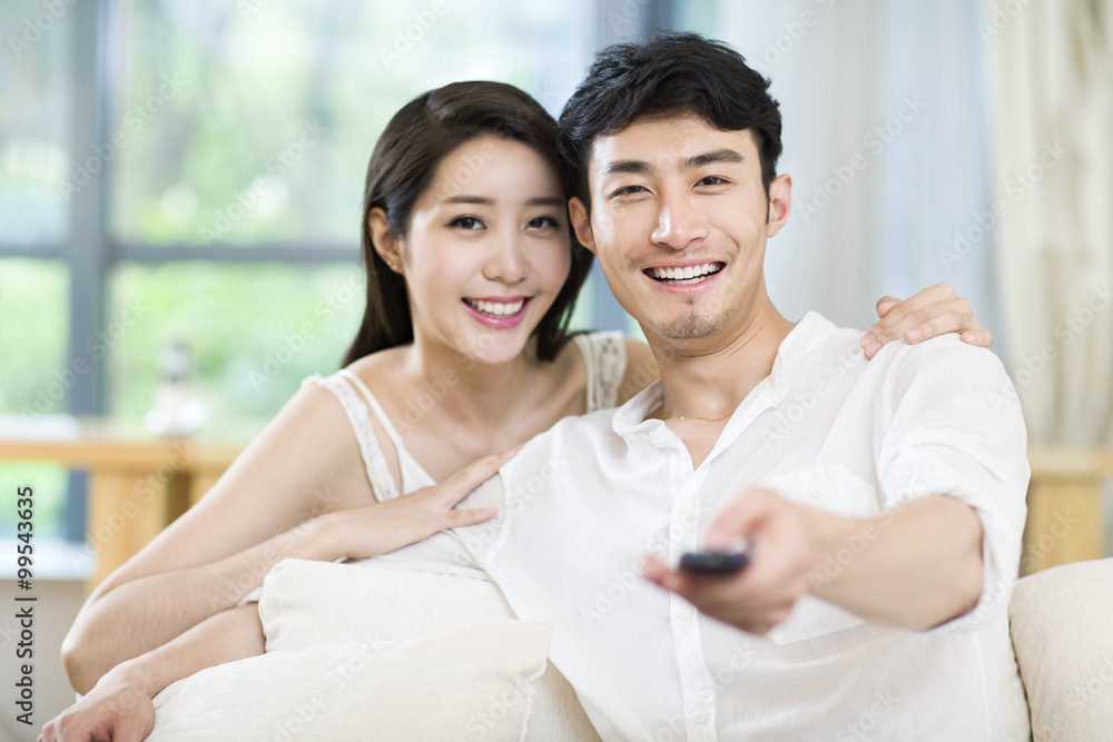 Cheerful young couple watching TV at home Cheerful young couple watching TV at home