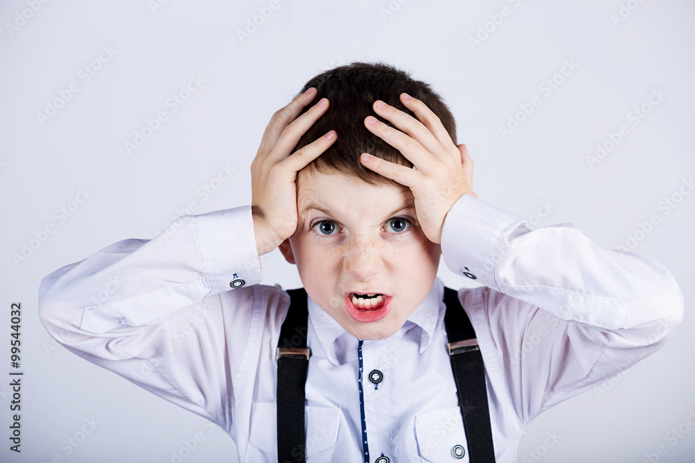 Stressed little boy having problems.Confused little boy with hand on his had over grey background.Stressed little boy having problems. Stressed little boy having problems.Confused little boy with hand on his had over grey background.Stressed little boy having problems.