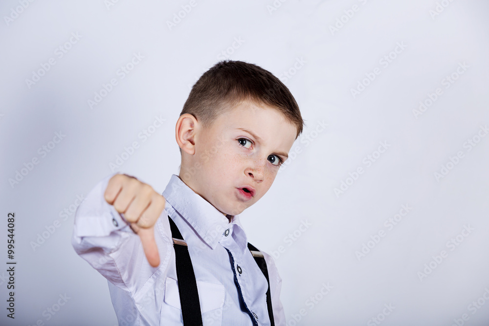 Upset little boy,child thumb down isolated over yellow background.Facial expression Upset little boy,child thumb down isolated over yellow background.Facial expression
