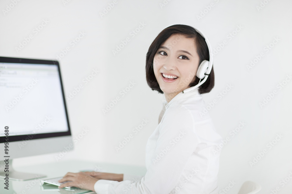 Cheerful businesswoman with headset in office Cheerful businesswoman with headset in office