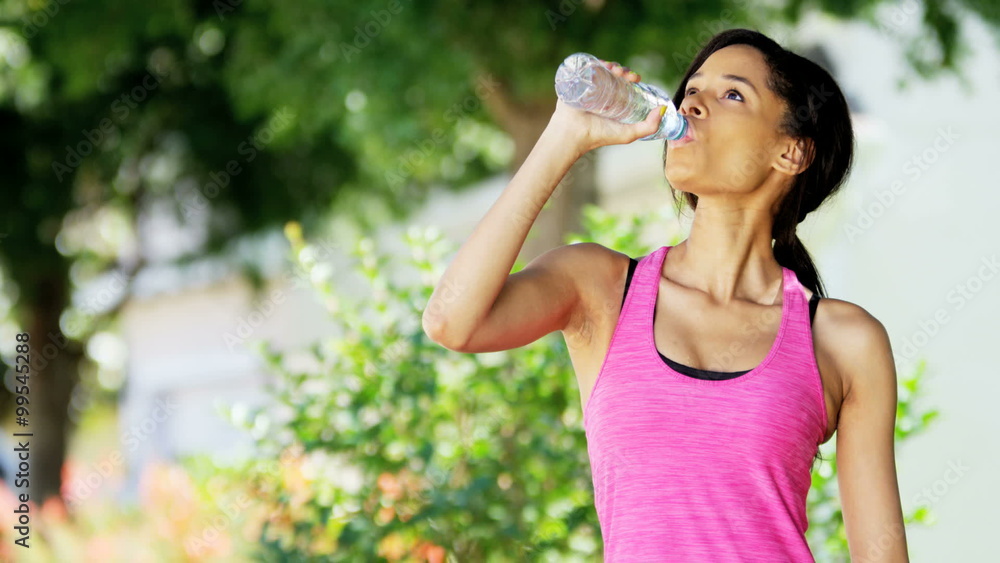 Young active African American female drinking water and training outdoor Young active African American female drinking water and training outdoor