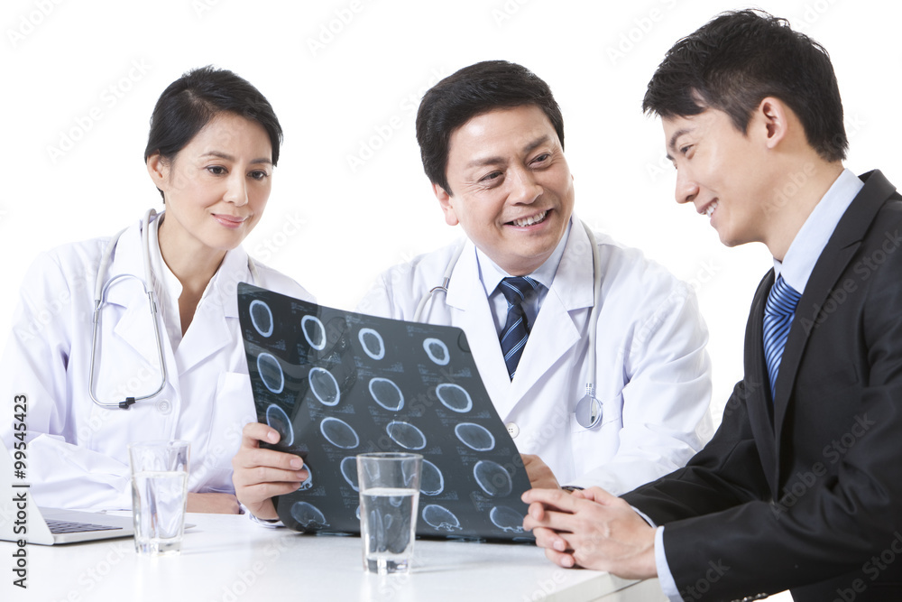 Professional doctors checking X-ray image with young man Professional doctors checking X-ray image with young man