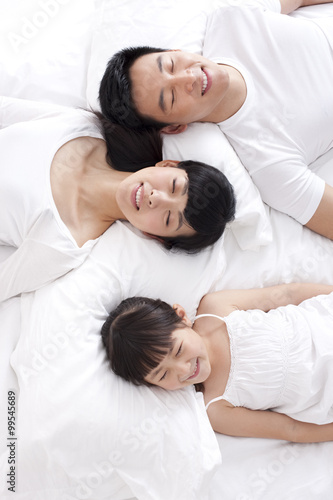 Happy family lying in bed