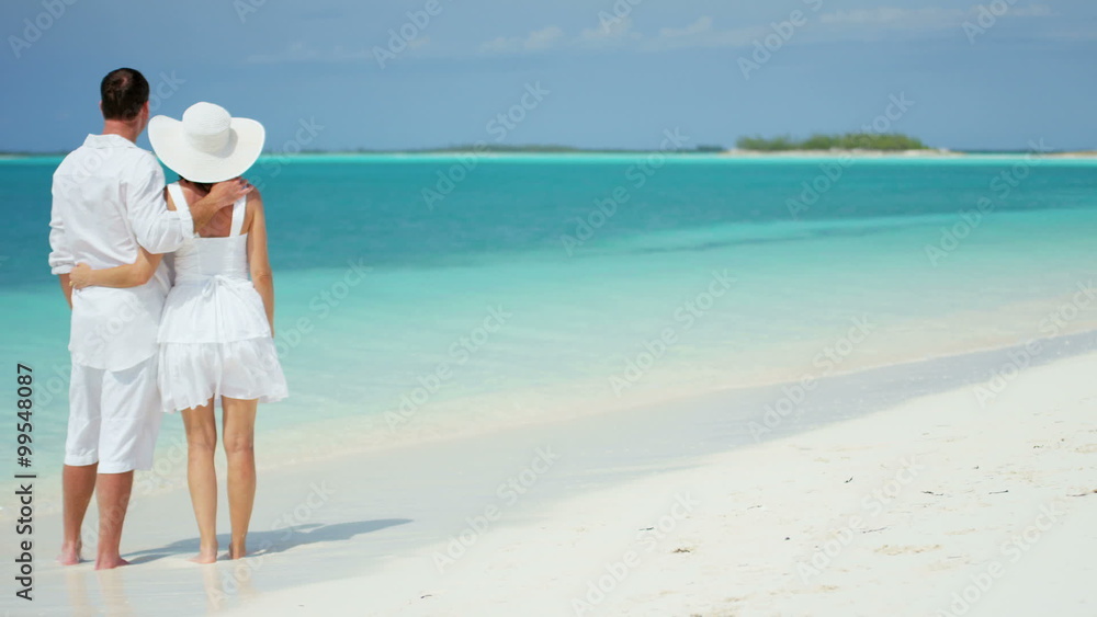 happy Caucasian male female couple white clothing sand ocean island vacation happy Caucasian male female couple white clothing sand ocean island vacation