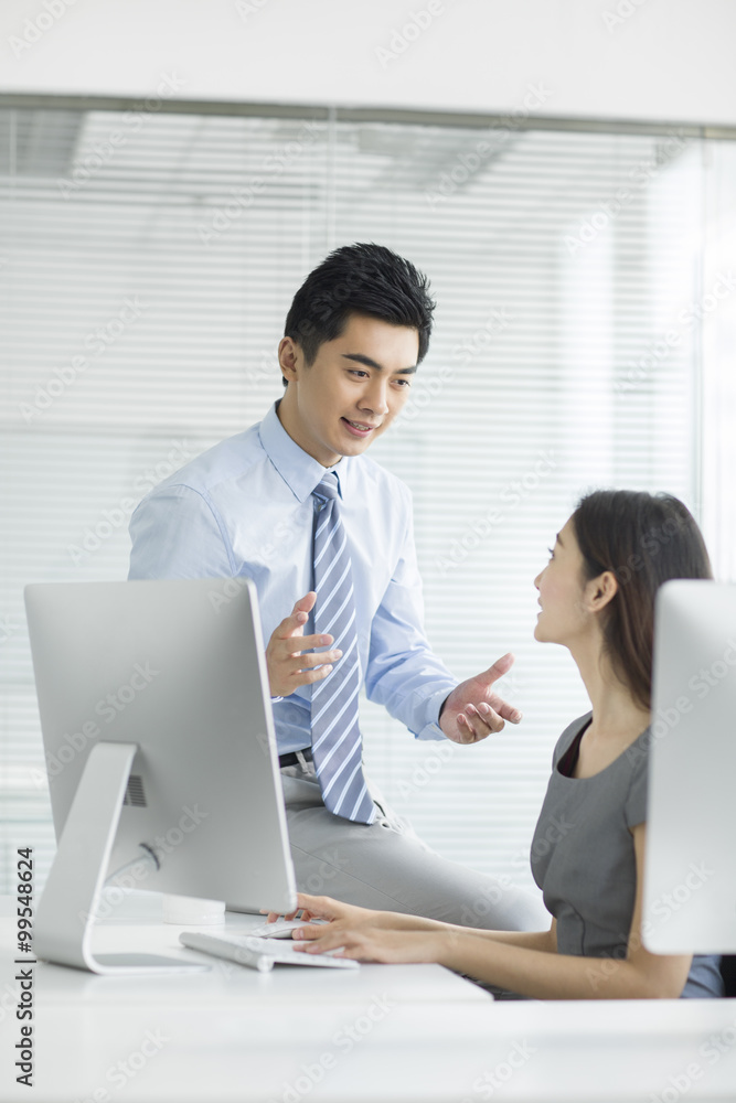 Young businesswoman and businessman talking in office Young businesswoman and businessman talking in office