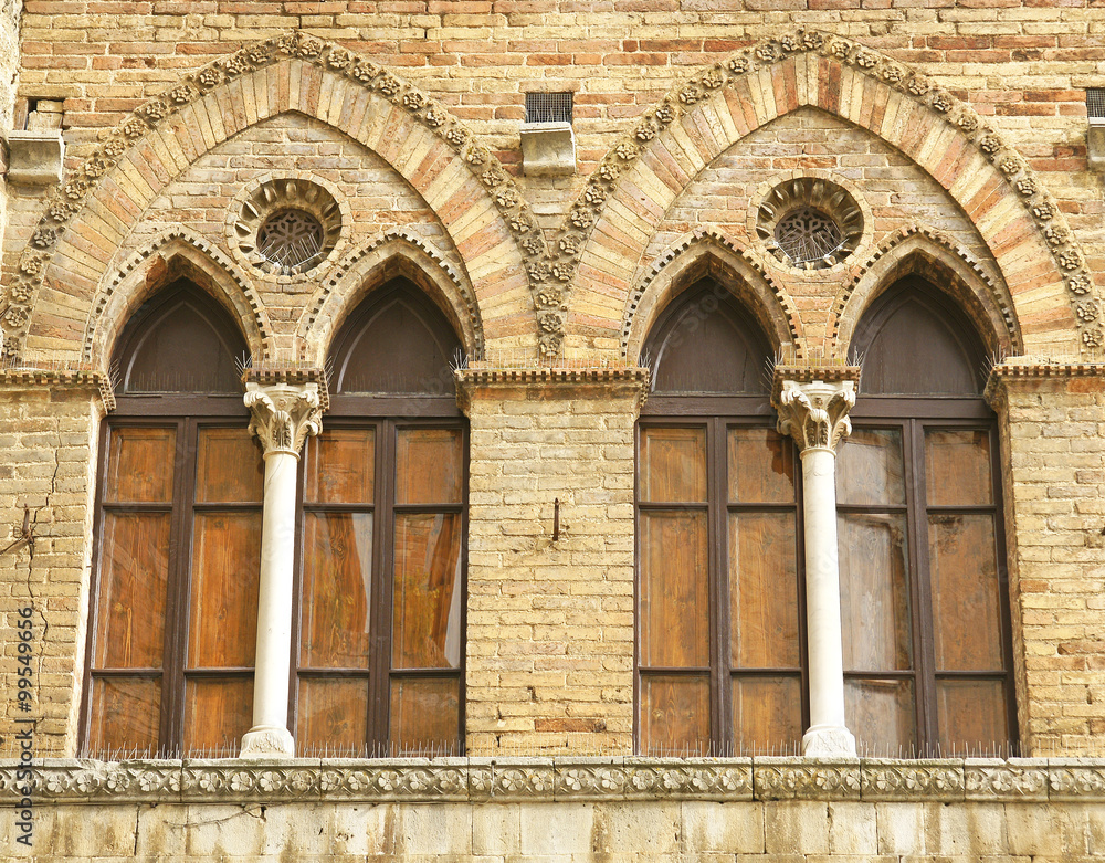 Detalle de ventanas de un edificio en San Gimignano, La Toscana, Italia