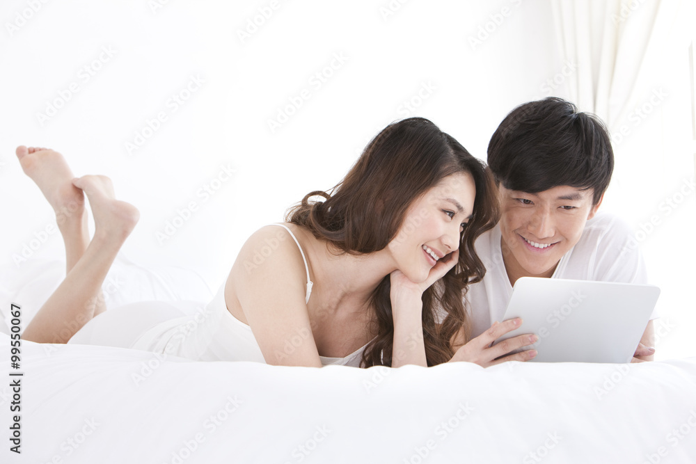 Young couple using digital tablet in bed Young couple using digital tablet in bed