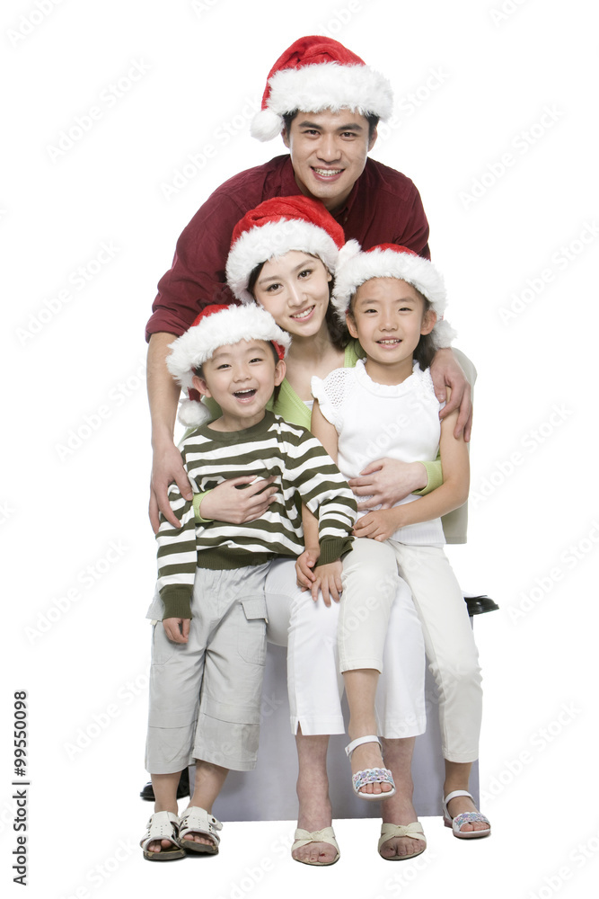 Portrait of family of four with Santa hats