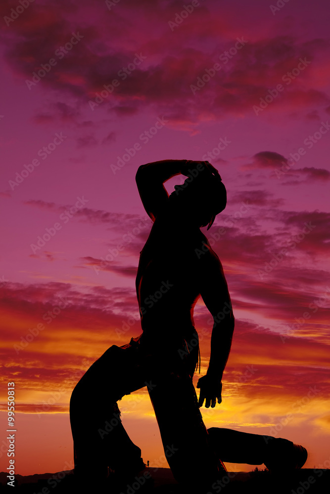 silhouette cowboy no shirt kneel one knee hand on hat look up