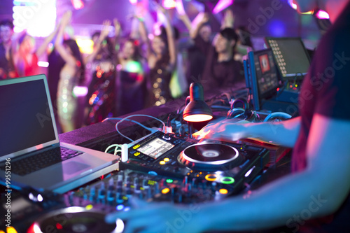 DJ doing record Scratching in nightclub photo