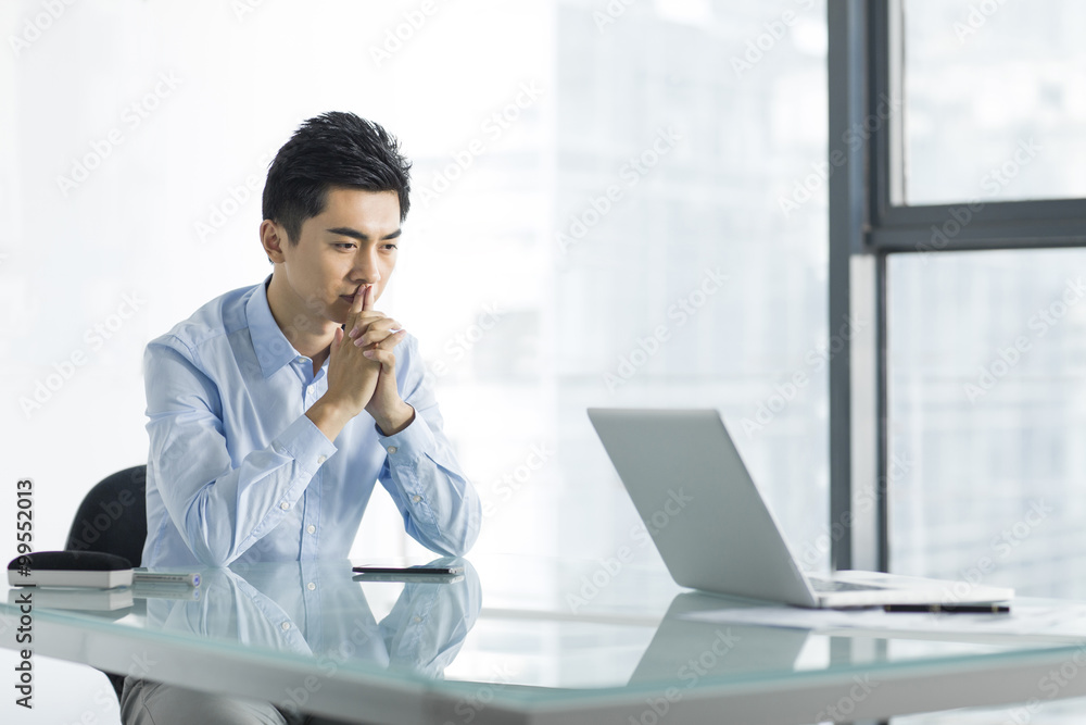 Young businessman thinking in office Young businessman thinking in office
