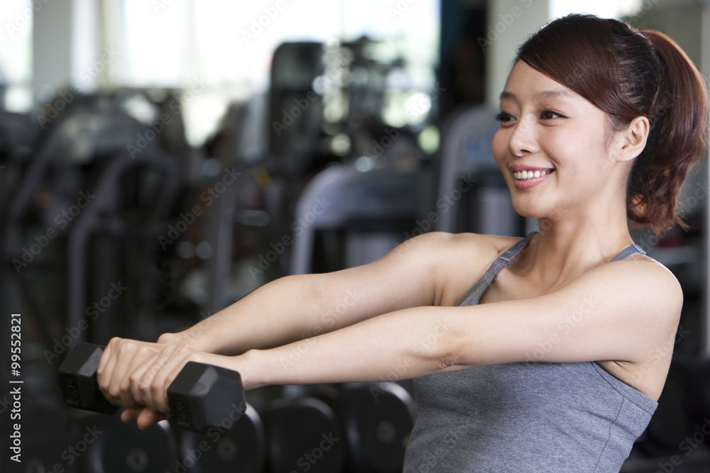 Fototapeta premium Young Woman Lifting Weights