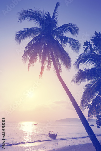 Vintage toned tropical beach at sunset.