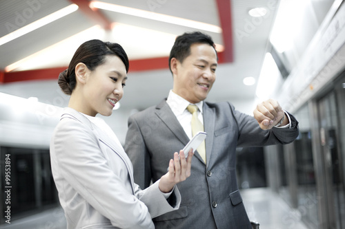 Business persons waiting for train on subway platform