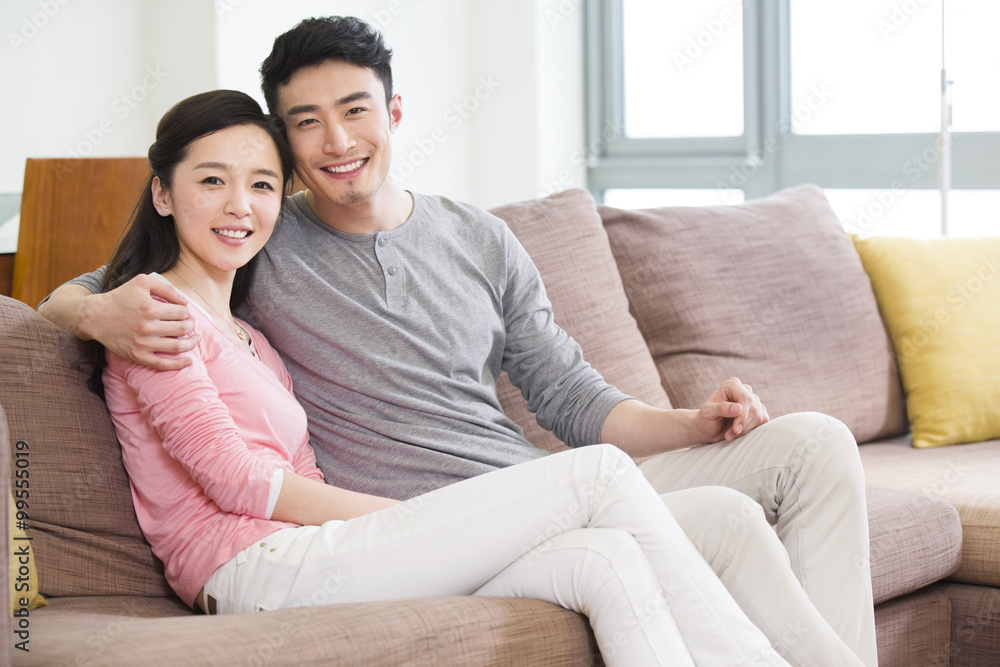 Happy young couple sitting on sofa Happy young couple sitting on sofa