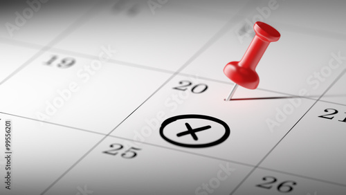 Concept image of a Calendar with a red push pin. Closeup shot of