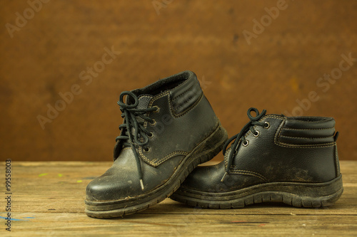 Dirty black shoes with old steel background