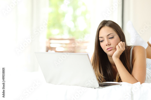 Girl bored browsing media in a laptop