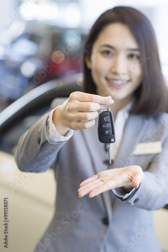 Saleswoman showing car key