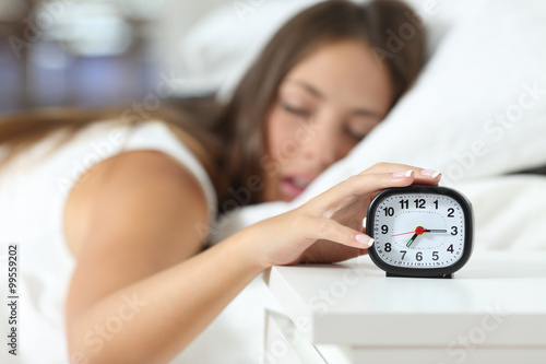 Wake up of an asleep girl stopping alarm clock